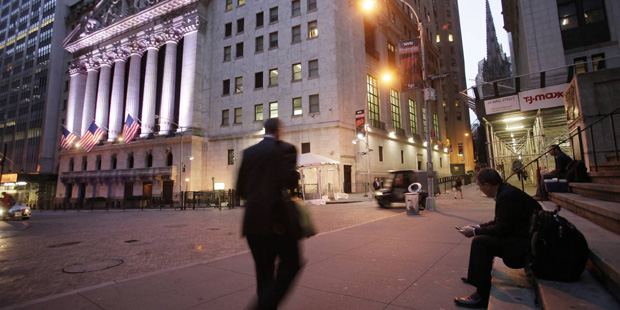 FILE - In this Oct. 8, 2014, file photo, a man walks to work on Wall Street, near the New York Stoc...