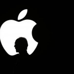 A man is silhouetted walking past the Apple logo during a product display for Apple TV following an Apple event Wednesday, Sept. 9, 2015, in San Francisco. Apple staked a new claim to the living room on Wednesday, as the maker of iPhones and other hand-held gadgets unveiled an Internet TV system that's designed as a beachhead for the tech giant's broader ambitions to deliver a wide range of information, games, music and video to the home. (AP Photo/Eric Risberg)