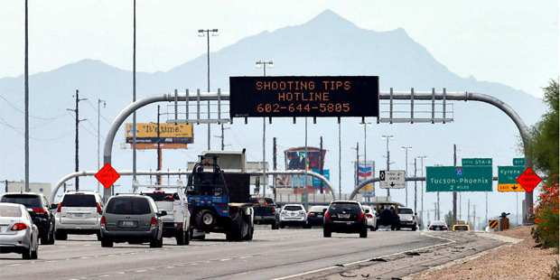 An Arizona Department of Transportation sign gives a hotline number for information on the recent f...