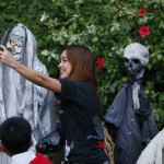 A resident takes a selfie of Halloween effigies outside a house to celebrate Halloween, the eve of the observance of All Saint's Day among Roman Catholics Saturday, Oct. 31, 2015 at suburban Makati city east of Manila, Philippines. Roman Catholics and other Christians all over the world pay their respects to the dead every Nov.1 with prayers and visits to cemeteries and memorial parks. (AP Photo/Bullit Marquez)