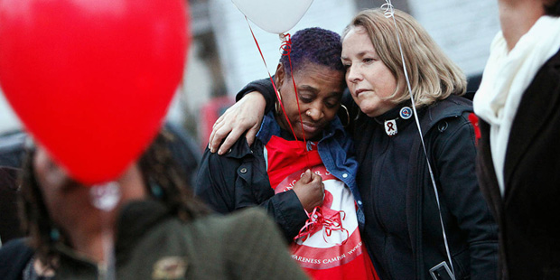 From left, Angela Vick and Julieta Giner hug before releasing balloons to mark World AIDS Day on Tu...