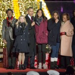 President Barack Obama, center, with from left to right, singer Andra Day, Aloe Blacc, actress Reese Witherspoon, daughters Malia and Sasha, mother-in-law Marian Robinson and first lady Michelle Obama, sing onstage during the National Christmas Tree Lighting ceremony at the Ellipse in Washington, Thursday, Dec. 3, 2015. (AP Photo/Pablo Martinez Monsivais)