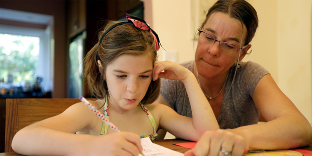 Stacey Jacobson-Francis works on math homework with her 6 year old daughter Luci Wednesday, May 14,...