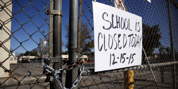 A gate to Birmingham Community Charter High School is locked with a sign stating that school is clo...