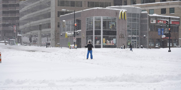 A man tries to cross an intersection in the snow, Saturday, Jan. 23, 2016, in Washington.  A blizza...