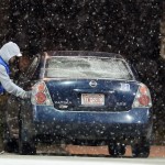 A man fills his car with gas at a station on Ninth Street as snow begins to fall before sunrise Friday, Jan. 22, 2016, in Durham, N.C. A massive blizzard began dumping snow on the southern and eastern United States on Friday, with mass flight cancellations, five states declaring states of emergency and more than 2 feet (60 centimeters) predicted for Washington alone. (Chuck Liddy/The News & Observer via AP)