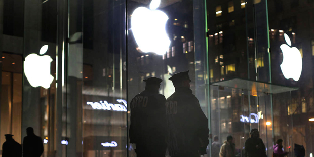 New York police officers stand outside the Apple Store on Fifth Avenue while monitoring a demonstra...