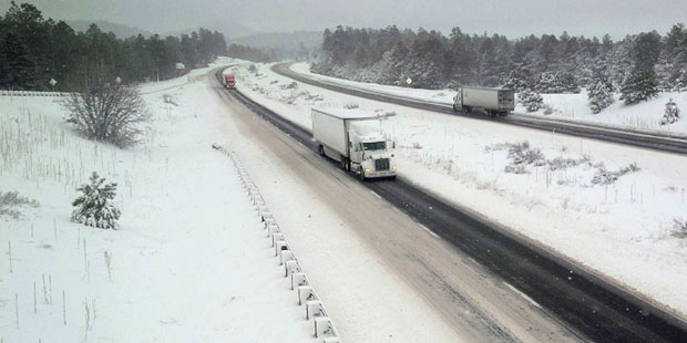 Trucks maneuver along a single, cleared lane in each direction of Interstate 40 west of Flagstaff, ...