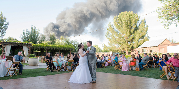 Carly and J.T. Morrissey enjoy their first dance in Gilbert, Ariz. as a five-alarm fire burns nearb...