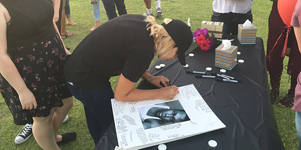 One of the mourners attending a vigil for Jason Josaphat signs his picture on Wednesday, June 15, 2...