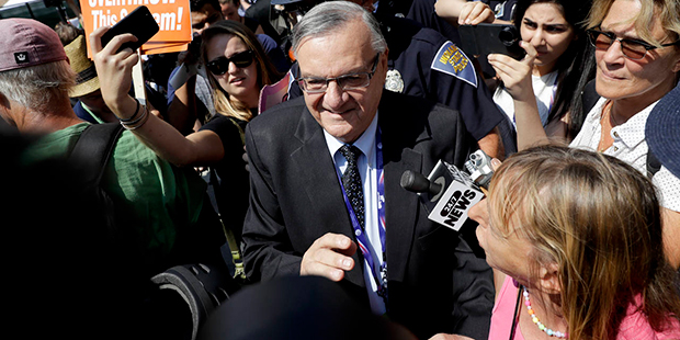 Sheriff Joe Arpaio of Maricopa County, Ariz., walks past a group of protester on Tuesday, July 19, ...