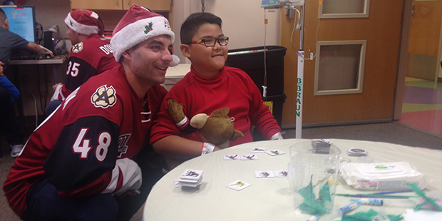 Arizona Coyotes forward Jordan Martinook with a child at Phoenix Children's Hospital. (Photo by Mik...