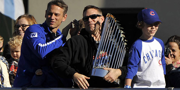 Chicago Cubs president of baseball operations Theo Epstein holds the Commissioner's Trophy while so...