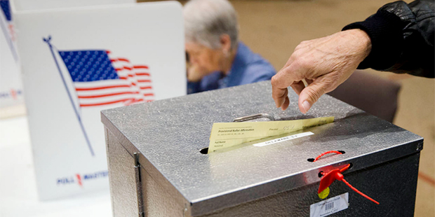 In this March 15, 2016, file photo, a primary election voter casts a provisional ballot at a pollin...