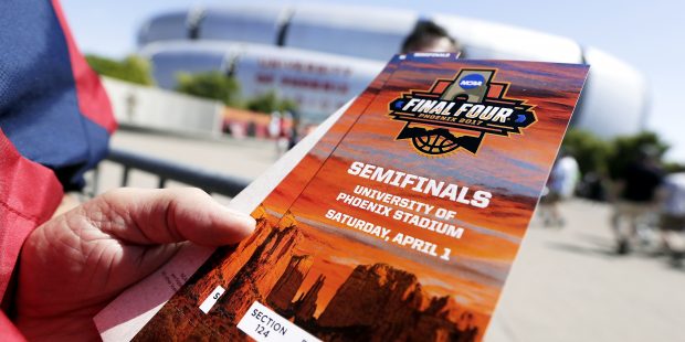 A fan holds tickets as he arrives at University of Phoenix Stadium before the semifinals of the Fin...