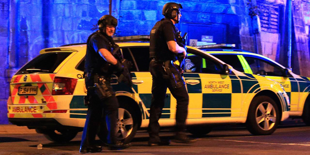 Armed police work at Manchester Arena after reports of an explosion at the venue during an Ariana G...