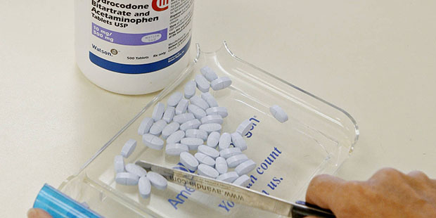 FILE - In this Aug. 5, 2010 file photo, a pharmacy tech poses for a picture with hydrocodone bitart...