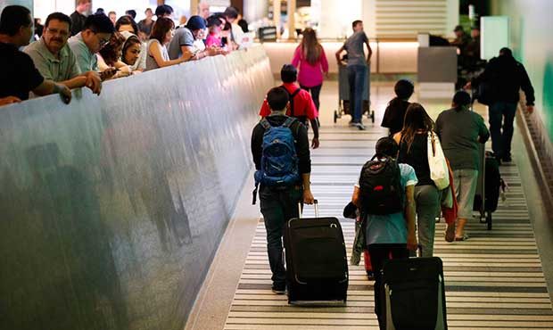 Travelers make their way up the arrival ramp at the Tom Bradley International Terminal at the Los A...