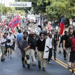 White nationalist demonstrators walk through town after their rally was declared illegal near Lee Park in Charlottesville, Va., Saturday, Aug. 12, 2017. (AP Photo/Steve Helber)