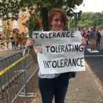 Colleen Cook, 26, holds a sign as hundreds of people are facing off in Charlottesville, Va., ahead of a white nationalist rally planned in the Virginia city's downtown, Saturday, Aug. 12, 2017.   Cook, a teacher who attended UVA, said she sent her black son out of town for the weekend. "This isn't how he should have to grow up," she said. (AP Photo/Sarah Rankin)