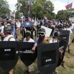 White nationalist demonstrators hold their ground as they clash with counter demonstrators in Lee Park in Charlottesville, Va., Saturday, Aug. 12, 2017.  Hundreds of people chanted, threw punches, hurled water bottles and unleashed chemical sprays on each other Saturday after violence erupted at a white nationalist rally in Virginia. At least one person was arrested.  (AP Photo/Steve Helber)