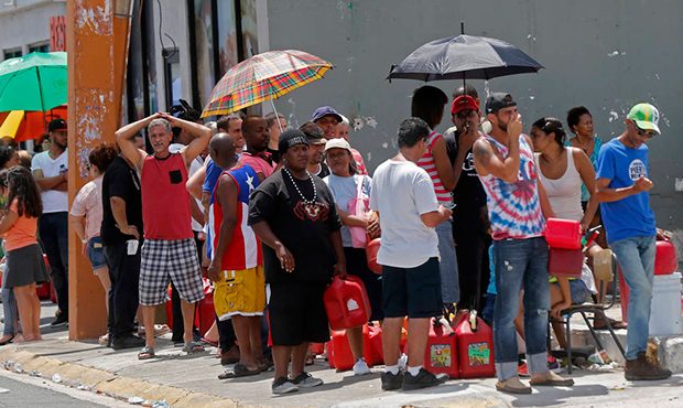 People line up with gas cans to get fuel from a gas station, in the aftermath of Hurricane Maria, i...