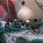 People stretch a net over a balloon before inflating it for the Thanksgiving Day parade in New York, Wednesday, Nov. 22, 2017. Sand-filled sanitation trucks and police sharpshooters will mix with glittering floats and giant balloons at a Macy's Thanksgiving Day Parade that comes in a year of terrible mass shootings and a deadly truck attack in lower Manhattan. (AP Photo/Seth Wenig)
