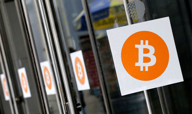 FILE - In this Monday, April 7, 2014 file photo, Bitcoin logos are displayed at the Inside Bitcoins...