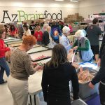 Volunteers with Arizona Brainfood fill bags of food for Valley schoolchildren to take home over the weekend. (KTAR News/Griselda Zetino)