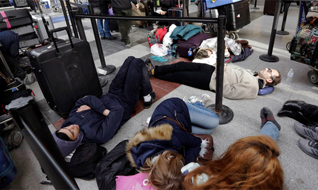 Avianca passengers lay on the floor while waiting for their flight at New York's John F. Kennedy Ai...