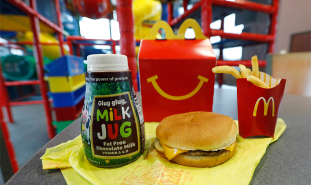 A Happy Meal featuring non-fat chocolate milk and a cheeseburger with fries, are arranged for a pho...