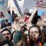 People hold their hands up with messages written on them during the "March for Our Lives" rally in support of gun control, Saturday, March 24, 2018, in Washington. (AP Photo/Alex Brandon)