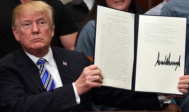 President Donald Trump holds up a proclamation on aluminum during an event in the Roosevelt Room of...
