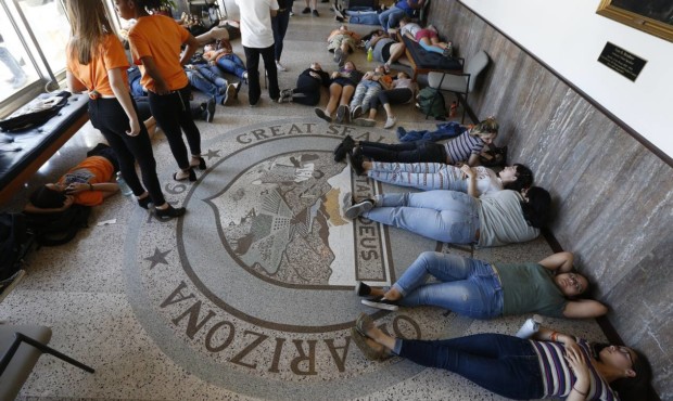Local high school students hold a "die-in" in the latest protest against gun violence at the Arizon...