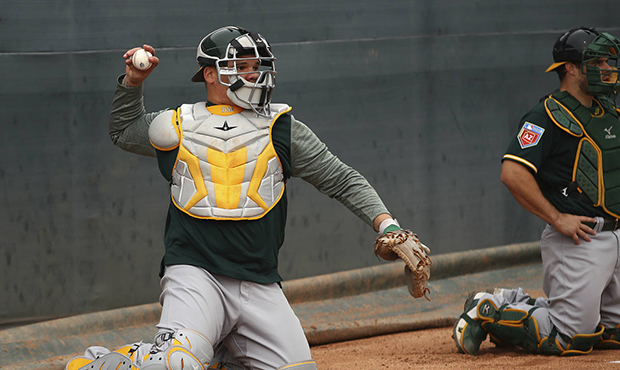 Oakland Athletics catcher Bruce Maxwell, left, throws during a spring training baseball practice on...