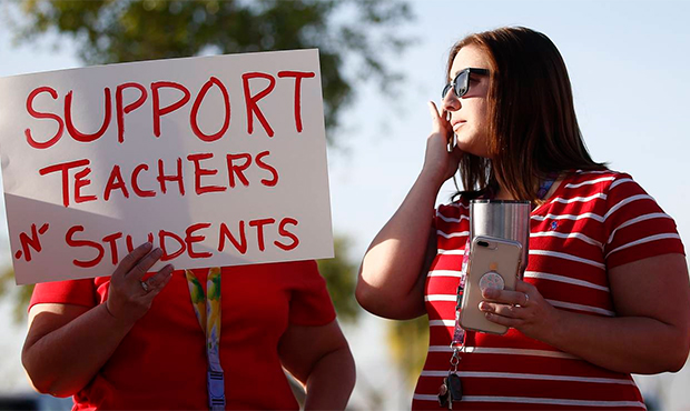 Stefanie Lowe, right, wipes away a tear as she talks with fellow teacher Nanette Swanson, as they j...