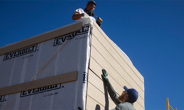 Roman Coppola (top) and Benjamin Strouse install siding on one of the tiny houses, which have high ...