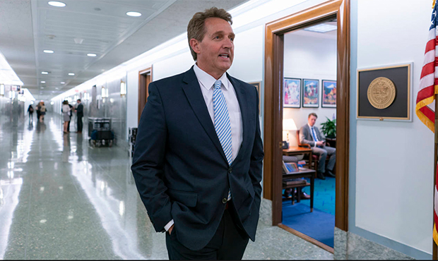 Sen. Jeff Flake, R-Ariz., is queried by reporters about changing his vote to yes on President Trump...