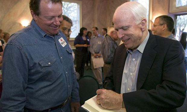 Sen. John McCain R-Ariz., right, autographs his book for Dennis Molnar, left, at a McCain campaign ...