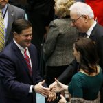 Arizona Gov. Doug Ducey, left, shakes hands with state Sen. Michelle Ugenti-Rita,  R-Scottsdale, second from right, and state Rep. John Kavanagh, R-Fountain Hills, right, after the governor spoke at the state of the state address where he talked about Arizona's economy, new jobs, and the state revenue Monday, Jan. 14, 2019, in Phoenix. (AP Photo/Ross D. Franklin)