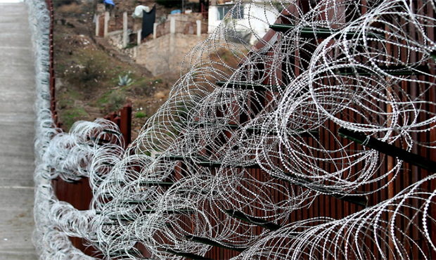 The additional concertina wire can be seen on the border fence in Nogales, Ariz, on Tuesday, Feb. 4...