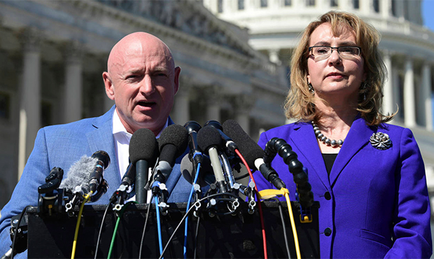 FILE- In this Oct. 2, 2017, file photo former Rep. Gabrielle Giffords, D-Ariz., right, listens as h...