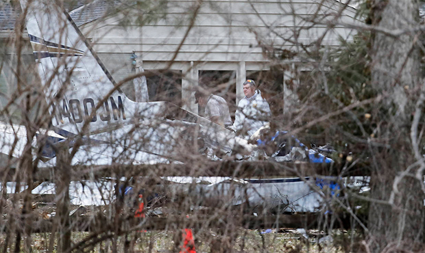 Wreckage is strewn across the backyard of a home at the scene of a plane crash on Rollymeade Ave., ...