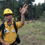 Fire information officer Joe Zwierzchowski talks to journalists during a Thursday, July 25, 2019, tour of an area scorched by fire in the Coconino National Forest near Flagstaff, Ariz. Hundreds of firefighters got the upper hand on the larger wildfire thanks to cooler weather. (AP Photo/Felicia Fonseca)