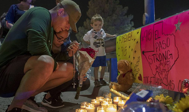 Rene Aguilar and Jackie Flores pray at a makeshift memorial for the victims of Saturday's mass shoo...