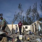 
              George Bolter, left, and his parents walk through the remains of his home destroyed by Hurricane Dorian in the Pine Bay neighborhood of Freeport, Bahamas, Wednesday, Sept. 4, 2019. Rescuers trying to reach drenched and stunned victims in the Bahamas fanned out across a blasted landscape of smashed and flooded homes Wednesday, while disaster relief organizations rushed to bring in food and medicine. (AP Photo/Ramon Espinosa)
            