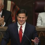 Arizona Republican Gov. Doug Ducey, foreground, gestures during his State of the State address as he talks about Arizona's economy, new jobs, prison reform, and education as Senate president Karen Fann, R-Prescott, right, and House Speaker Rusty Bowers, R-Mesa, left, listen in on the opening day of the legislative session at the Capitol Monday, Jan. 13, 2020, in Phoenix. (AP Photo/Ross D. Franklin)