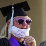 Linda White stands in her driveway in her cap, gown and a face mask as she celebrates graduating with a Bachelor of Science in elementary education and special education from Grand Canyon University during the coronavirus outbreak, Friday, May 1, 2020, in Simi Valley, Calif. White would have gone to a graduation ceremony in Arizona if not for the stay-at-home restrictions due to the coronavirus. (AP Photo/Mark J. Terrill)