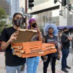 Demonstrators in Phoenix bring pizza, saying you can't “protest on an empty stomach.” (KTAR Photo/Gabriel Gamiño)