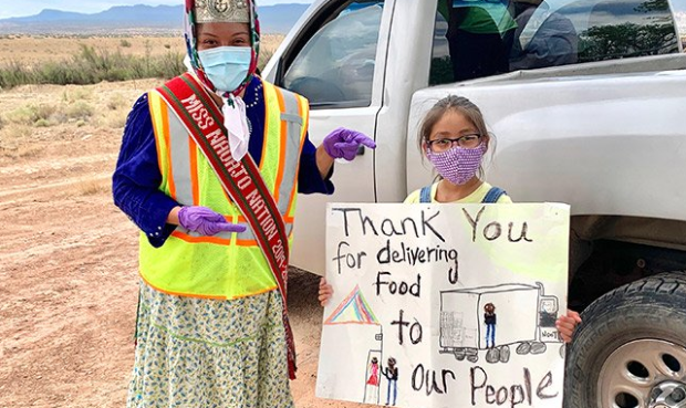 A child thanks Miss Navajo Nation Shaandiin Parrish for distributing food, water and cleaning suppl...